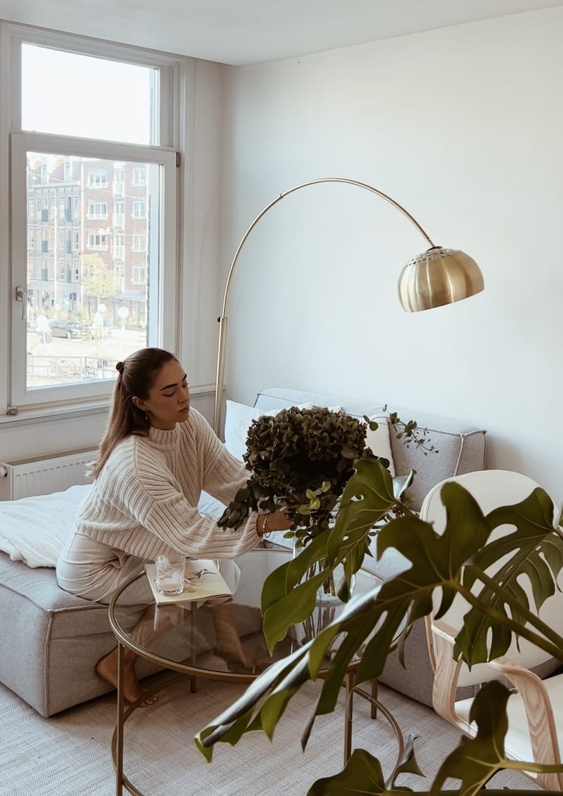 A glass of water with two slices of lime, on white linen in raking daylight